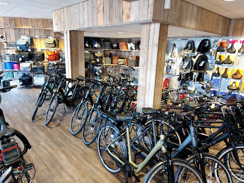 De showroom met steigerhouten wanden, rijen fietsen, tassen, kinderzitjes en zadels.